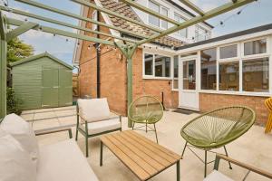 a patio with two chairs and a table and a bench at The Beach House in Overstrand