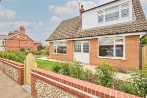 a house with a brick fence in front of it at The Beach House in Overstrand