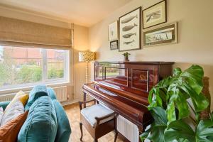 a living room with a piano and a couch at The Beach House in Overstrand +5 photos