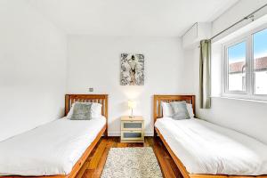 two beds in a room with a window at Lovely 2 Bedroom Holiday Chalet near Sidmouth in Sidmouth