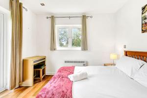 a white bedroom with a bed and a window at Lovely 2 Bedroom Holiday Chalet near Sidmouth in Sidmouth