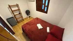 a living room with a red couch and a fan at Casa na Praia do Frances in Marechal Deodoro +27 photos