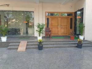 a front door of a house with potted plants at Girbar Dhaam Near By Prem mandir in Vrindāvan