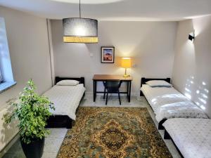 a room with two beds and a table with a table at Panorama Widok in Ostróda