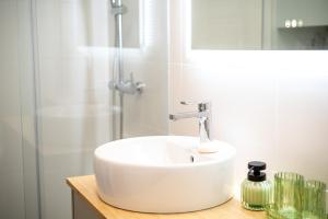 een witte wastafel in een badkamer met een douche bij Charming Estoril Apt One Min Walk to the Beach in Estoril +26 foto's