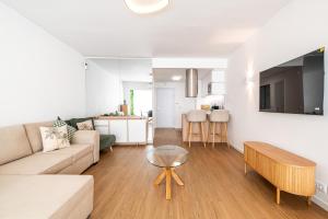 een woonkamer met een bank en een tafel bij Charming Estoril Apt One Min Walk to the Beach in Estoril