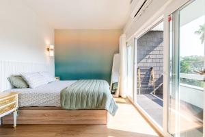 een slaapkamer met een bed en een glazen schuifdeur bij Charming Estoril Apt One Min Walk to the Beach in Estoril