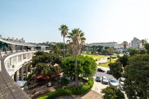 uitzicht op een stad met palmbomen en een straat bij Charming Estoril Apt One Min Walk to the Beach in Estoril