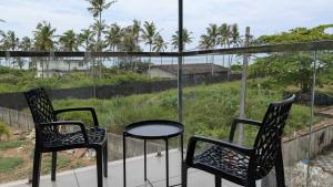 two chairs and a table on a balcony with a view at Grand Beach Villa in Kannur