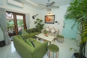a living room with green couches and a table at GGH - Ocean Nest, Goa in Candolim