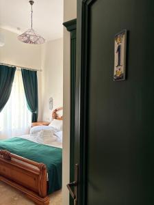 a bedroom with a bed with green sheets and a window at Casa Iulian in Oradea +10 photos