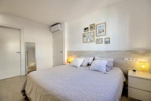 Un dormitorio blanco con una cama grande con almohadas. en G Reserva Mimoses 2 - ImmoBarneda, en Empuriabrava 24 fotos más
