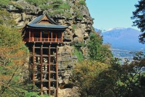 a building on the side of a mountain at ワイナリーや酒蔵巡りなどにおすすめの宿 小諸市 築100年の古民家 Chojuro -長寿楼- in Komoro