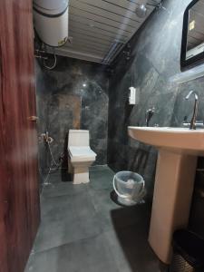 a bathroom with a toilet and a sink at Pineview Escapes in Jālāpahār