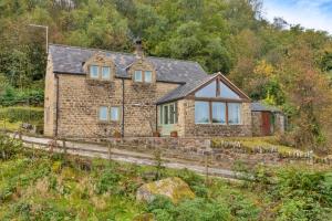 a brick house on the side of a hill at Finest Retreats - Rough Close Farm Cottage in Ashover
