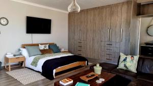 een slaapkamer met een bed en een woonkamer bij Stay at 64 Omeya in Windhoek