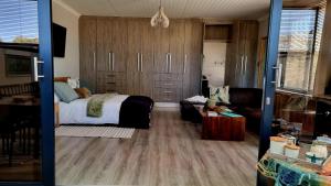 een slaapkamer met een bed en een bank bij Stay at 64 Omeya in Windhoek +25 foto's