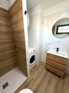 a bathroom with a washing machine and a sink at Moderno apartamento con vistas al mar in Playa del Aguila