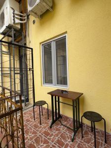 un tavolo e due sedie accanto a un muro giallo di Casa Iulian a Oradea