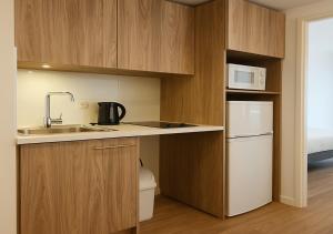 una cucina con un lavello e un frigorifero bianco di Zenao Appart'hôtels Le Raincy Thiers a Le Raincy