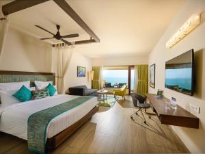 a hotel room with a bed and a desk at The Bheemli Resort Managed by AccorHotels in Visakhapatnam