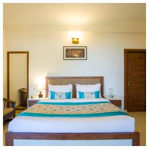 een slaapkamer met een groot bed met blauwe kussens bij Sanskari Nivas family holiday home in Kasauli