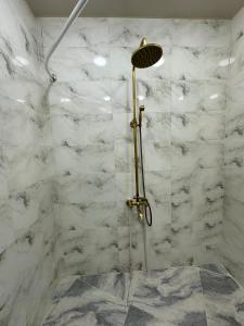 a shower in a bathroom with white marble walls at GR Qobu merisi in Inasharidzeebi