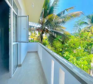 康提Inside Out Nature Villa的享有棕榈树景致的阳台