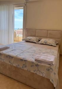 Un dormitorio con una cama grande con ventana. en ApartHotel Sea & Back view studios, en Durrës