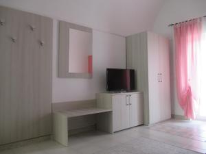 a living room with a tv and a cabinet with a television at Vacanza alla Chiesa Diruta in Grottole