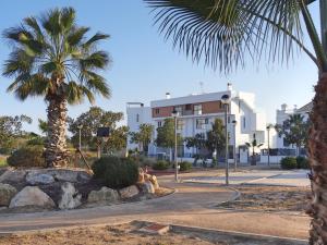 Los DolsesにあるApartment Orihuela Costa Golf 650の建物前のヤシの木