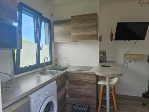 a kitchen with a sink and a washing machine at Studio Belle Place in Le Gosier
