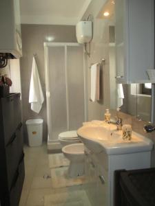 ein weißes Bad mit einem WC und einem Waschbecken in der Unterkunft Vacanza alla Chiesa Diruta in Grottole