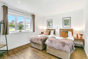 Dos camas en una habitación con ventana. en Bright & Spacious 2 Bed Holiday Chalet in Sidmouth, en Sidmouth
