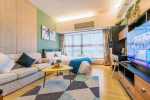 広州市にあるXuanzhi Hotelのソファとテレビのあるリビングルーム