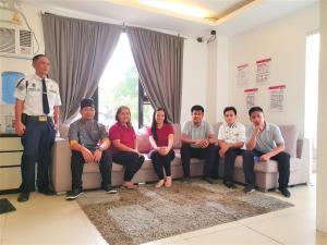 a group of people sitting on a couch with a police officer at Spiral Suites Hotel in Manila