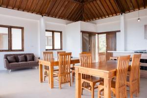 Un comedor con mesa y sillas de madera. en Torok Papa villa, en Selong Belanak