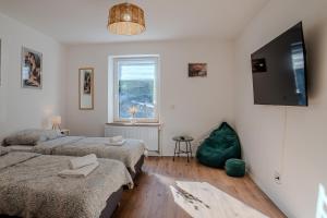a bedroom with two beds and a flat screen tv at Stylische Wohnung - Messe Essen nah - Wifi & Parken in Essen