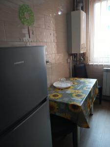 a kitchen with a table and a refrigerator in it at Apartament Central in Piatra Neamţ