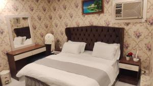 a bedroom with a large bed and a mirror at شاليهات مدينة الحدائق لبيوت العطلات in Baljurashi