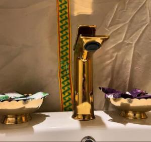 a gold faucet and two bowls on a sink at Desert Marhaba luxury Camp in Merzouga +25 photos