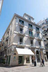 a tall white building with a white umbrella in front of it at Palazzo Olimpia - Luxury Retreat in Salerno