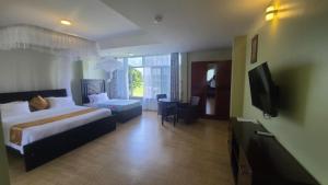 a hotel room with a bed and a television at Majestic Nile Hotel Limited in Pakwach
