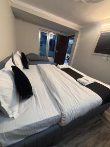 a large white bed with pillows on top of it at The Mist Nainital Hotel in Nainital +1 photo