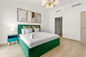 um quarto com uma cama verde e um lustre em FIRST CLASS 2BR Yas Island Living em Abu Dhabi mais 39 fotografias