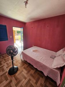 a bedroom with a bed and a chair in it at Pousada Brilho do Mar in Guriú