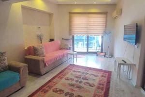 un soggiorno con divano rosa e tappeto di Central 1 Bed w Balcony Sea Views & Roof Terrace a Alanya