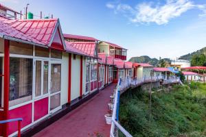 a row of houses with red roofs on a hill at Aurevelle Kastura Resort Kanatal - Mountain View Rooms in Kanatal +38 photos