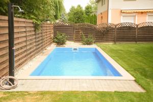 a swimming pool in a yard next to a fence at Blue Lake Appartman in Siófok