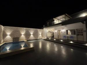 a house with a swimming pool at night at Casa Oceanus - 3 Bedroom - Sea Facing Pool Villa - Ganpatipule in Ganpatipule